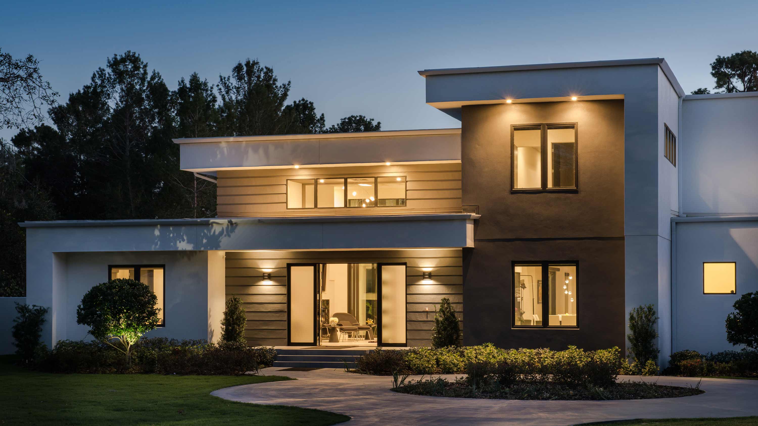 Modern two‑story home with exterior lighting and contemporary architectural design.