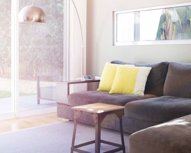 crestron touch panel in a living room with a grey couch