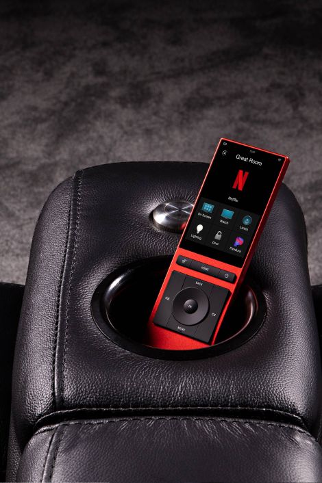 Red Neeo remote sitting in black leather couch